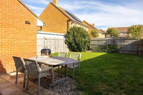 a table and chairs in the backyard of a house at Coastal Home for 6 in The Witterings in East Wittering