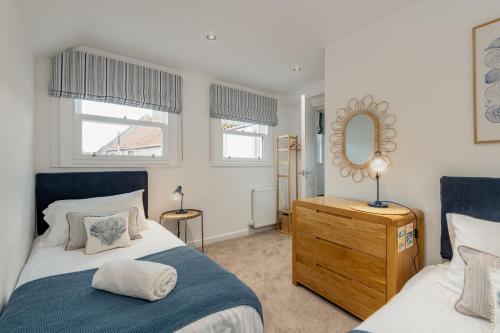 a bedroom with a bed and a dresser and a mirror at Murray's Neuk in Anstruther