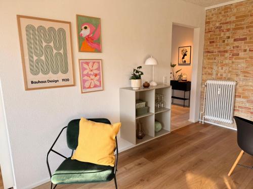 a living room with a chair with a yellow pillow at Cozy, totally renovated apartment, sleeps 6 in Herning