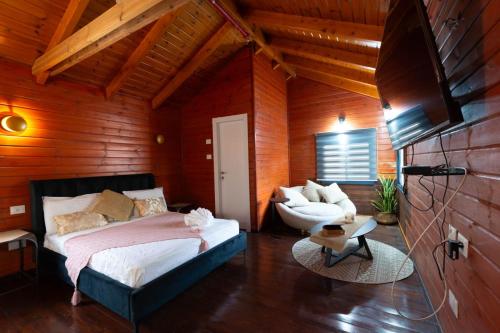 a bedroom with a bed and a chair in a room at Pnina Yafa BaGalil Zimmer in Qiryat Shemona