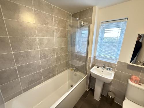 une salle de bain avec une baignoire, un lavabo et des toilettes dans l'établissement Cayton Bay Cottage, à Cayton