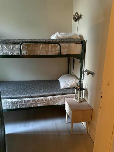 two bunk beds in a room with a lamp and a table at Linsell in Sveg