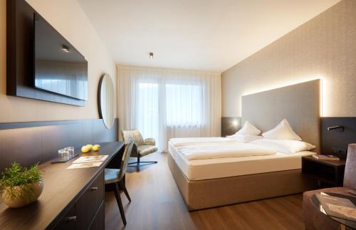 ein Hotelzimmer mit Bett und Schreibtisch in der Unterkunft Hotel Ladurner in Meran