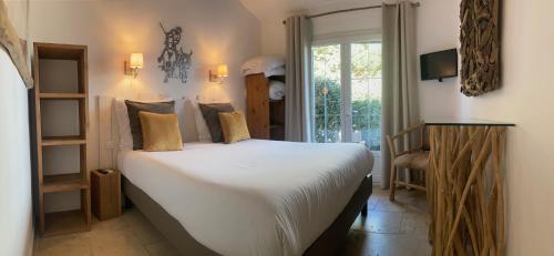 een slaapkamer met een groot bed en een raam bij Hôtel Spa Mas des Rièges in Saintes-Maries-de-la-Mer