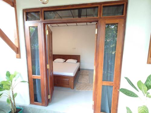 - une petite chambre avec un lit et une porte dans l'établissement Eco Heaven House, à Ahangama
