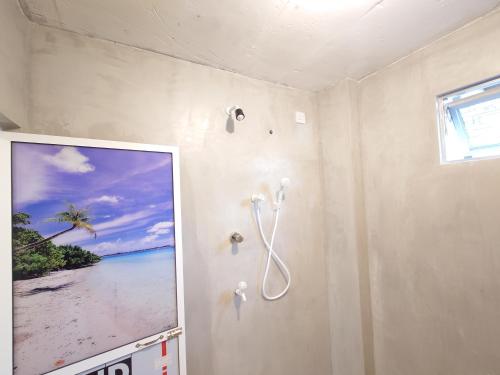 une salle de bain avec douche avec une photo de plage dans l'établissement Eco Heaven House, à Ahangama