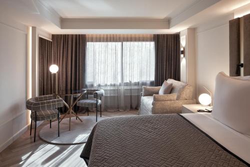 Una habitación de hotel con una cama, una mesa y sillas. en MIM Andorra Member of Melia Collection, en Escaldes-Engordany