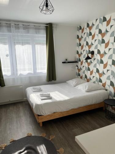 een slaapkamer met een groot bed in een kamer met ramen bij Les studios de l'Albatros in Saint-Nazaire