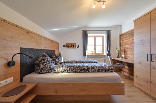 a bedroom with a bed and a desk and a window at Schmölz Robert in Rieden am Forggensee
