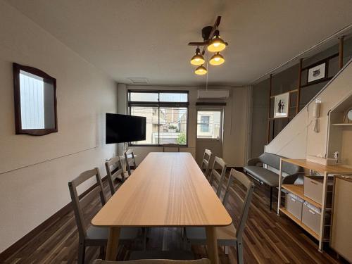 a conference room with a wooden table and chairs at とまるん桜山 in Nagoya