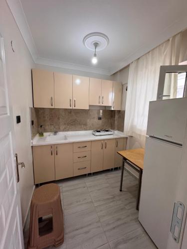 eine Küche mit einem weißen Kühlschrank und einem Tisch in der Unterkunft Orçın Apartments in Lapseki