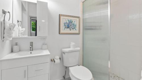 a white bathroom with a toilet and a shower at Casa Angelica Apt 103 steps to Sandy Beach in Rincon