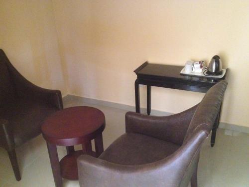 a room with a table and a chair and a table and stool at Kadoma Hotel & Conference Centre in Katoma