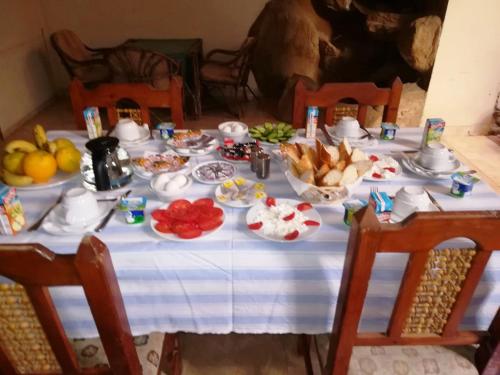 a table with plates of food and fruit on it at Kareem Hotel Luxor in Luxor