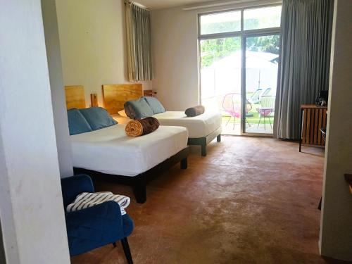 a hotel room with two beds and a balcony at El Turix Bacalar in Bacalar