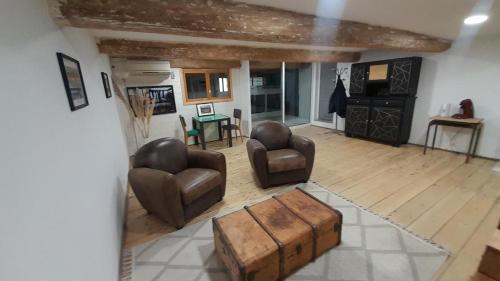 a living room with two chairs and a table at La commanderie in Homps