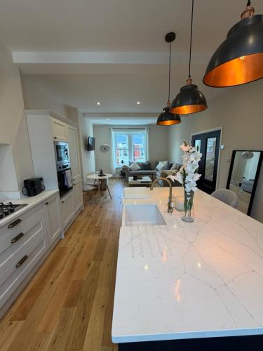 a kitchen and living room with a white counter top at Modern 2 Bed 2 Bath Apartment in Prime Jesmond Location in Newcastle upon Tyne