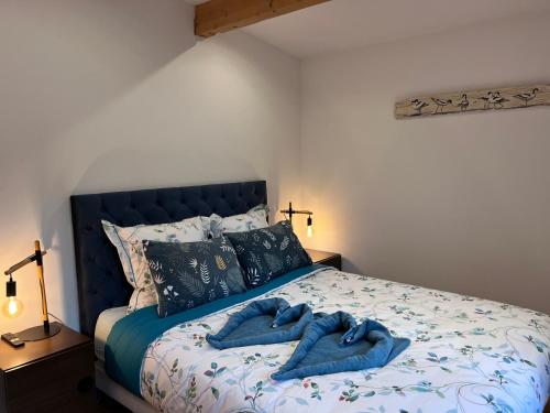 a bedroom with a bed with blue towels on it at Le P’tit Bois Doré in Blanquefort