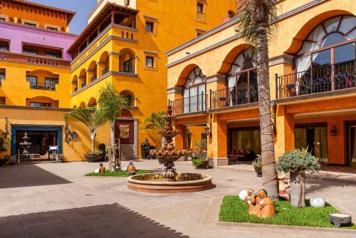 a yellow building with a fountain in a courtyard at Europe Villa Cortes GL in Playa de las Americas