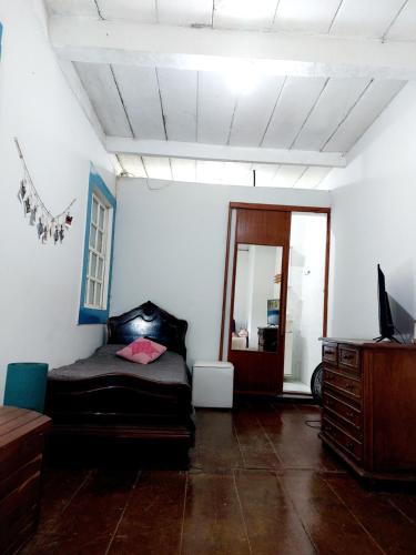 a living room with a bed and a mirror at Hospedagem Casa do Bem Ficar in Lumiar