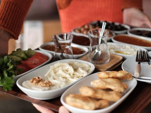 een tafel met borden met voedsel op een tafel bij Mona Glamping Caravan Suites in Seferihisar