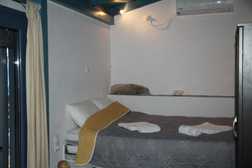 a small room with a bed and a window at Cavo Paradise Kimolos in Kimolos