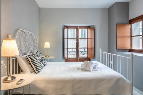 Un dormitorio con una cama blanca grande y una ventana en Francos Cathedral, en Sevilla