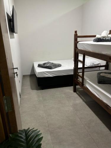 een slaapzaal met twee stapelbedden en een plant bij Apartamento no Centro de Bandeirantes Ar, TV Smart, Ar Condicionado e Frigobar in Bandeirantes
