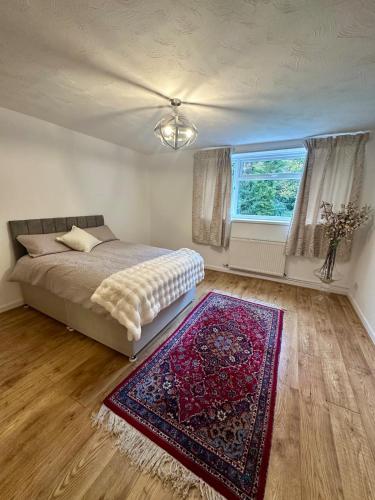 a bedroom with a bed and a rug and a window at Spacious apartment in Leigh woods in Bristol