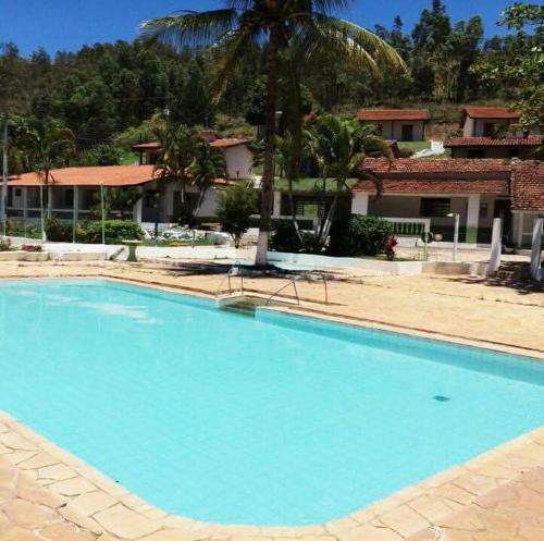 a large blue swimming pool in front of a building at Pousada Chalés Sierra in Serra Negra