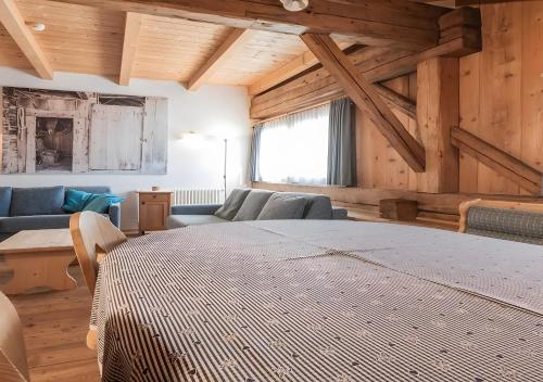 Una sala de estar con una cama grande y un sofá. en Plazores, en San Vigilio Di Marebbe