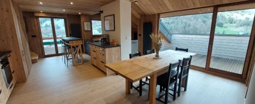 阿邦当斯Appartement Neuf 4 Pièces的配有木桌椅的厨房和餐厅