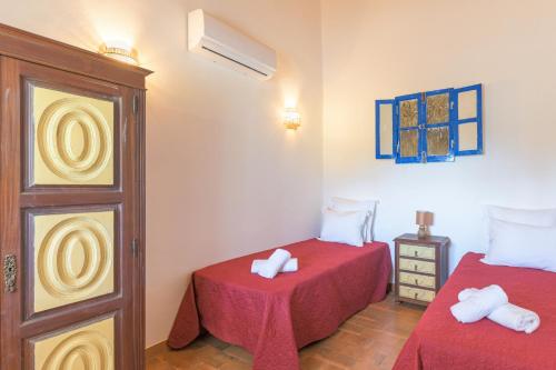 a bedroom with two beds with red sheets at Casa Da Ti Vanda in Zambujeiras