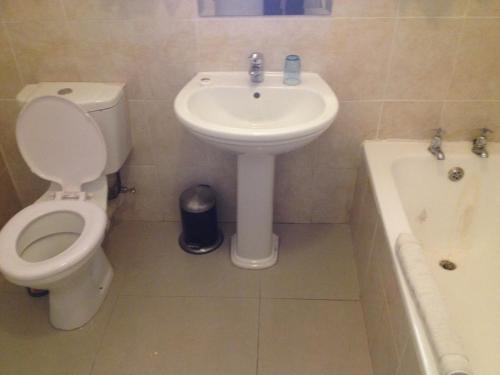a bathroom with a toilet and a sink and a tub at Kadoma Hotel & Conference Centre in Katoma