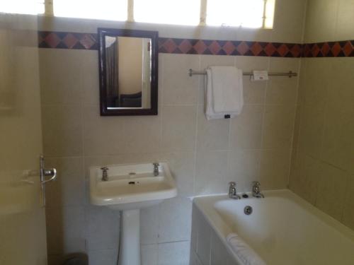 a bathroom with a sink and a bath tub at Kadoma Hotel & Conference Centre in Katoma