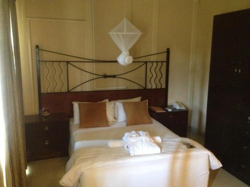 a bedroom with a large bed with white sheets at Kadoma Hotel & Conference Centre in Katoma