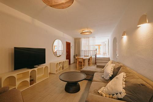 a living room with a couch and a flat screen tv at The Ibiza Oasis - Adults Only - Secret Suites in San Antonio Bay