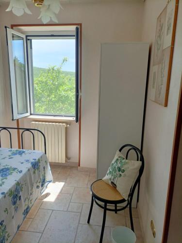 a room with a bed and a chair and a window at Casa Bea in Castiglione