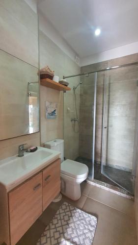 a bathroom with a shower and a toilet and a sink at HEAVEN BEACH in Sidi Rahal