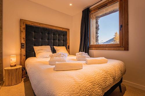 ein Schlafzimmer mit einem großen Bett mit zwei Handtüchern darauf in der Unterkunft Chalet Louisette luxe, Bain Nordique, 3 Vallées -Navette privée in Saint-Jean-de-Belleville