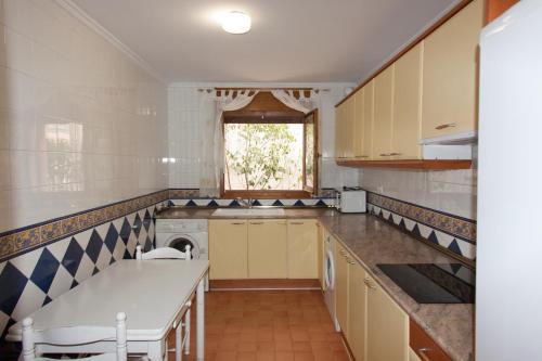 una cocina con armarios amarillos y una ventana en Apartamentos Río Guadalaviar, en Albarracín