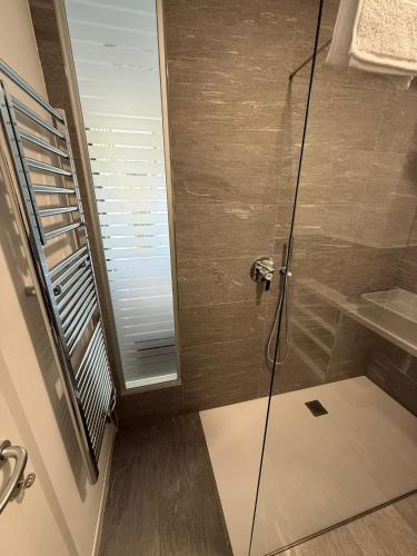 a shower with a glass door in a bathroom at Bovara 49 in Lecco