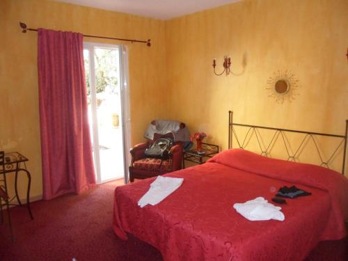 a bedroom with a red bed and a chair and a window at Chez Jules in Chalon-sur-Saône