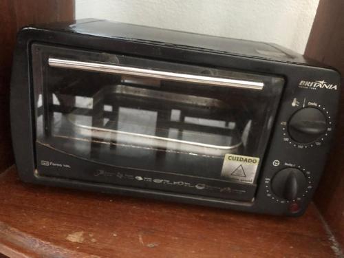 a black toaster oven sitting on top of a counter at Hospedagem Familia Lima in Belém