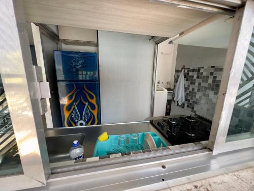 a kitchen window with a sink and a stove at Quartos Vila Olímpia 1 in Sao Paulo