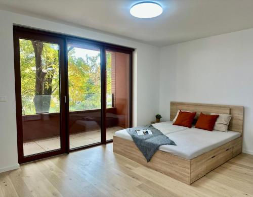 a bedroom with a bed and a large window at Bratislava in Nivy