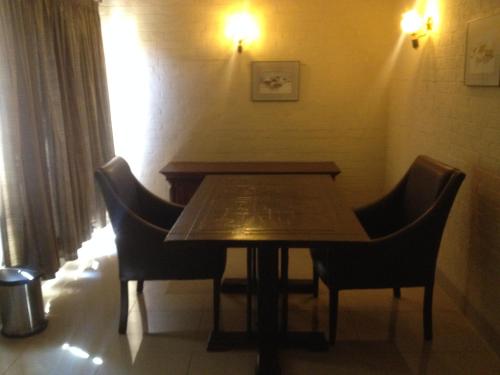 a wooden table and chairs in a room at Kadoma Hotel & Conference Centre in Katoma