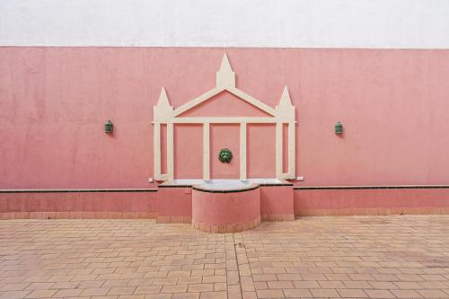 a pink wall with a white window on it at San Clemente House in Seville