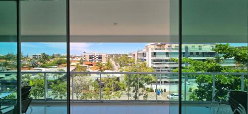 een raam met uitzicht op de stad bij Triplex Penthouse with Private Pool and Sea View in Rio das Ostras