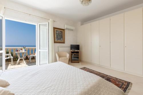 a bedroom with a bed and a view of the ocean at La Villa Alba by BarbarHouse in Leporano Marina